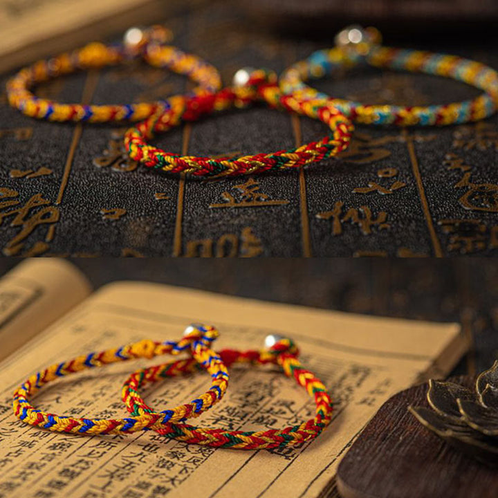 Bunte Glücksbänder Armband – Glück & Erfolg auf chinesischem Buch Flat Lay