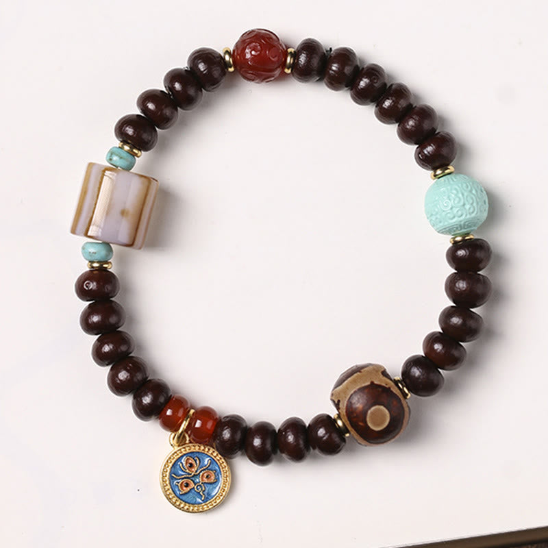 Bodhi Armband mit braunen Perlen, türkisem Stein und goldenem Anhänger.