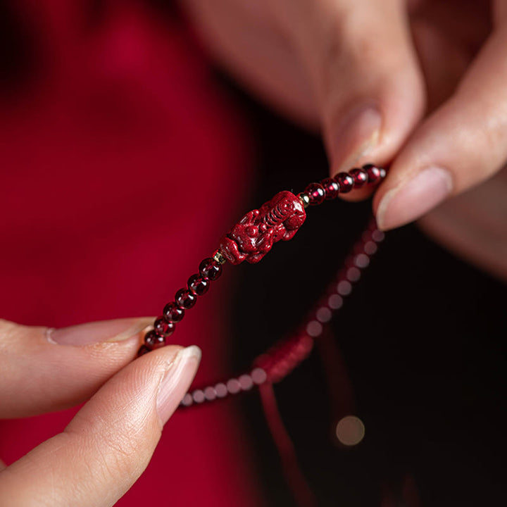 Rotes Granat Pixiu Armband mit Perlen elastisch getragen Handgelenk.