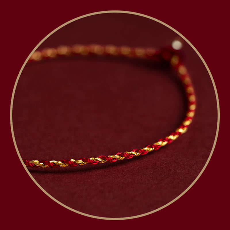 Rotes geflochtenes Armband mit goldenen Akzenten auf Burgunderhintergrund.
