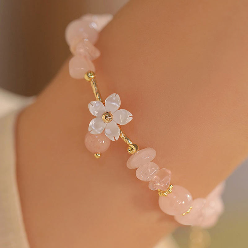 Rosenquarz Armband Kristall – Liebe am Handgelenk mit Blütenanhänger getragen