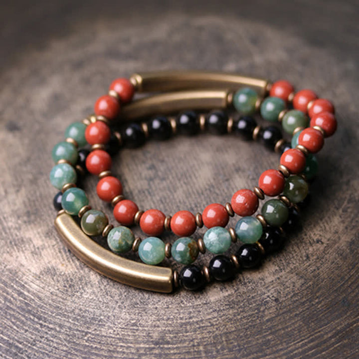 Drei elastische Armbänder mit roten Korallen, grünem Stein und schwarzem Obsidian Kristall.