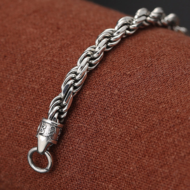 Geflochtenes Silberarmband mit Om Mani Padme Hum Verschluss elegant getragen