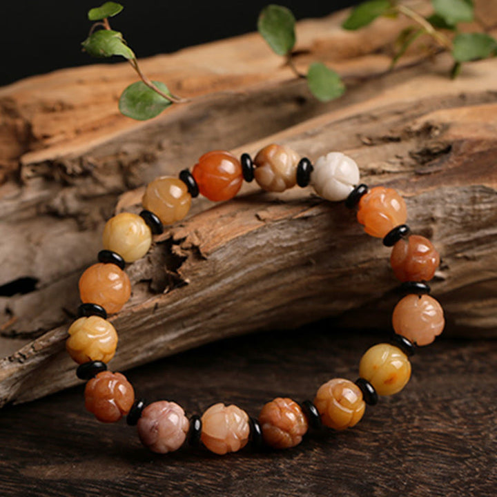 Jade Lotus Armband mit mehrfarbigen Steinen auf Holz Natur.