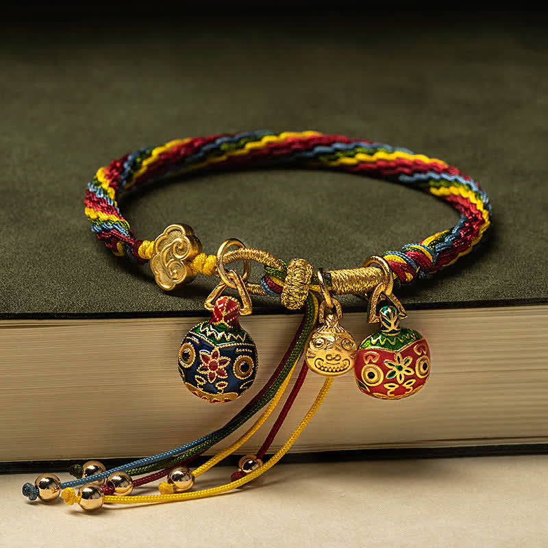 Mehrfarbiges Armband mit goldenen Anhängern auf Buch, elastisch.