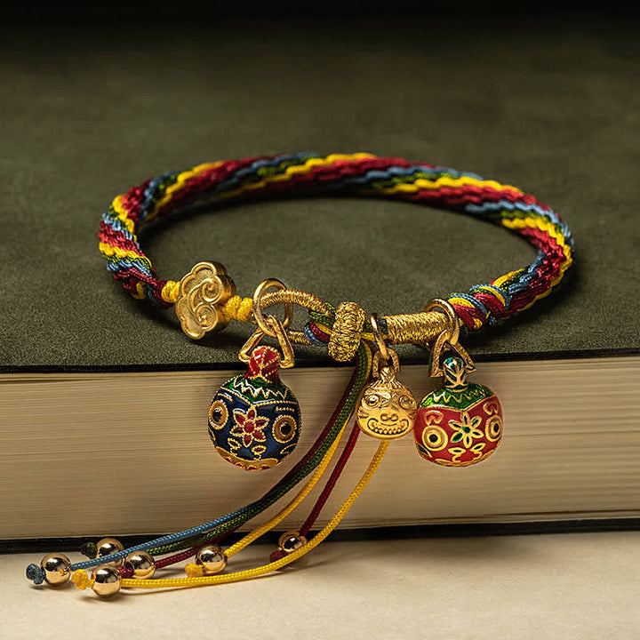 Mehrfarbiges Armband mit goldenen Anhängern auf Buch, elastisch.
