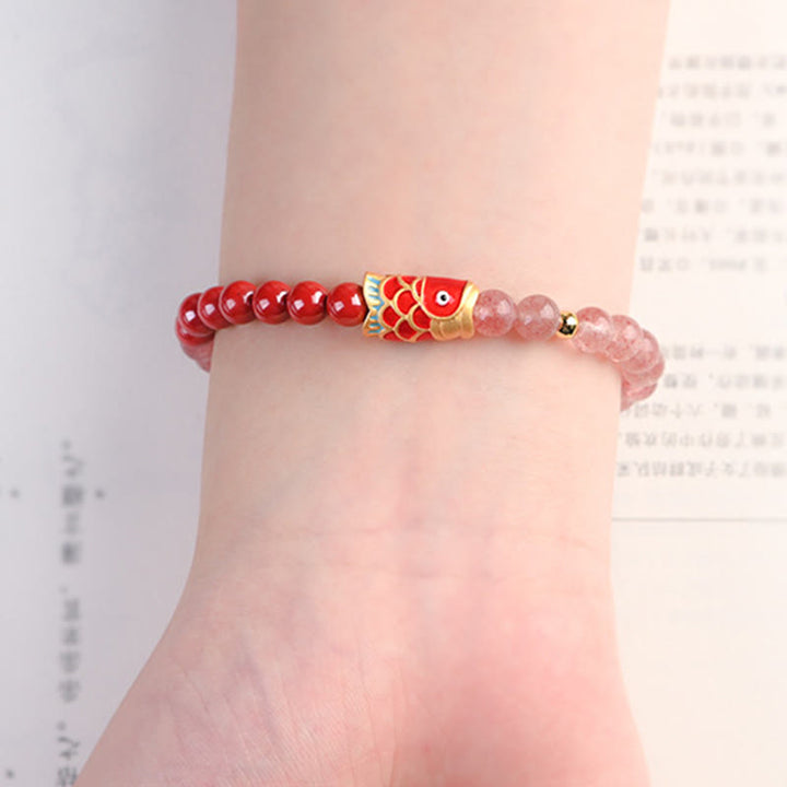 Armband Erdbeerquarz Zinnober Koi Fisch am Handgelenk getragen rosa rot