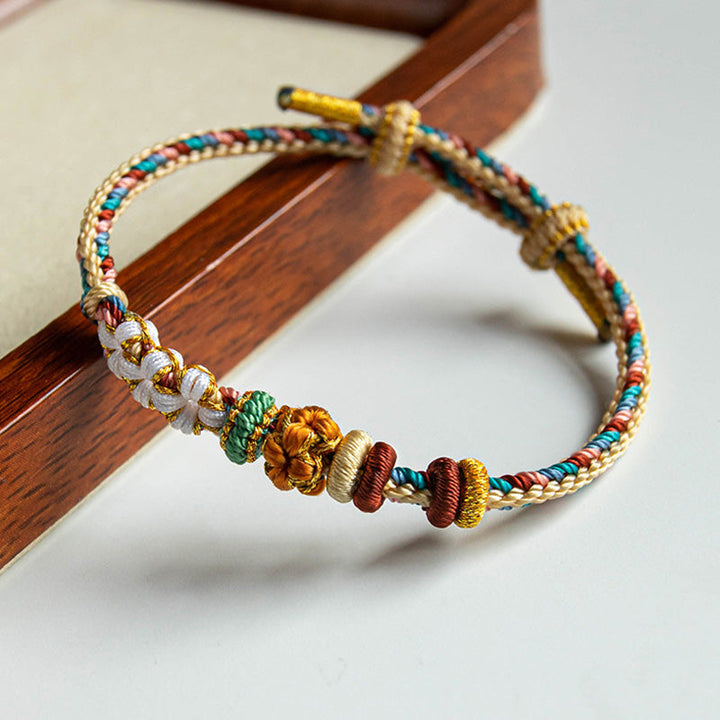 Armband Pfirsichblüte mit bunten Perlen Holzuntergrund Naturschmuck