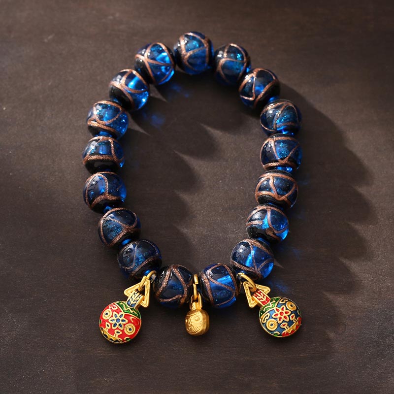 Armband mit blauen Perlen und goldenen Glücksbringern Anhängern elegant.