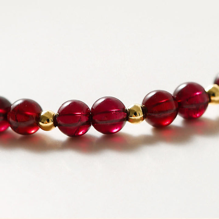 Rotes Granat Armband mit goldenen Perlen Nahaufnahme Flachware