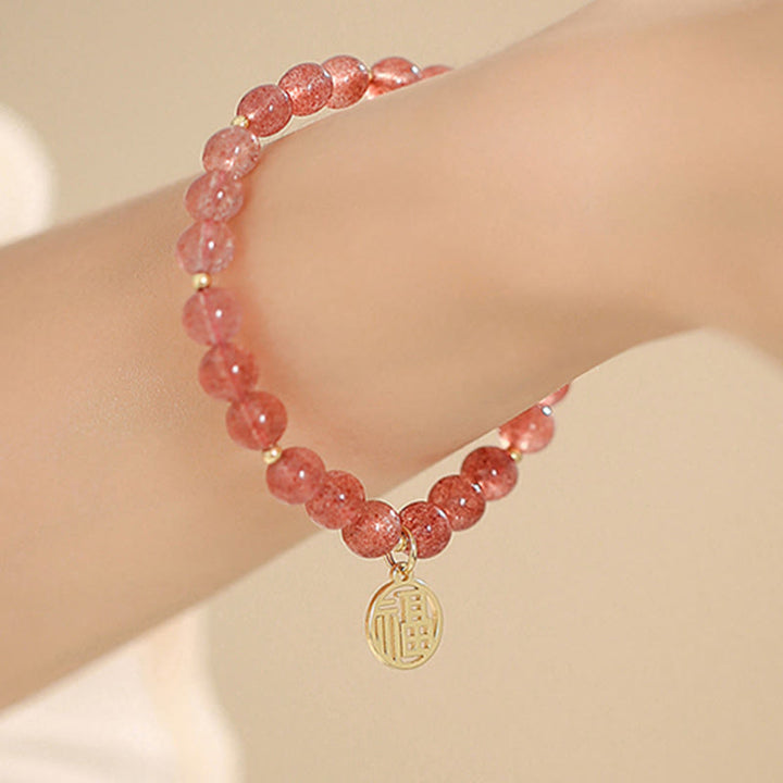 Armband Erdbeerquarz Fu-Zeichen Heilung, rosa Perlen elegant am Handgelenk