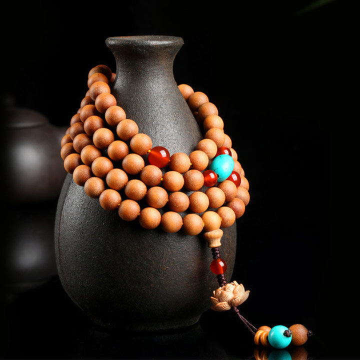 Armband Sandelholz Lotus mit Türkis und roten Perlen.