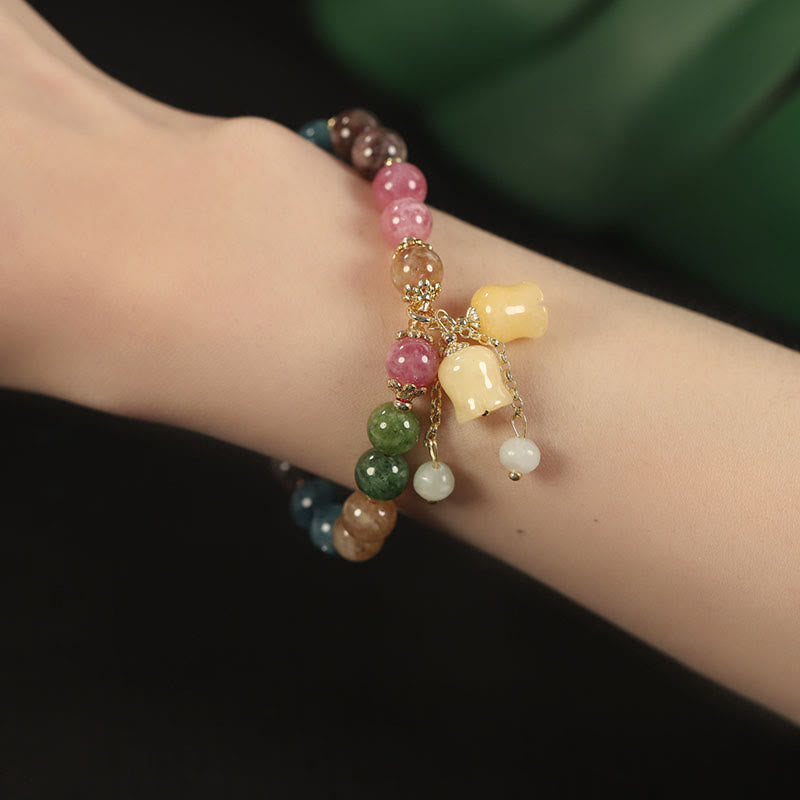 Buntes Turmalin Armband mit Blume und Perlen am Handgelenk getragen