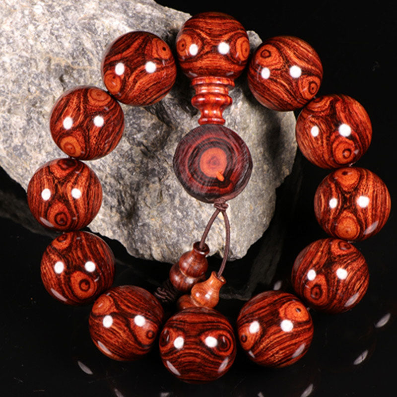 Armband Rosenholz mit weißen Punkten, Naturstein, Detailaufnahme auf Stein.