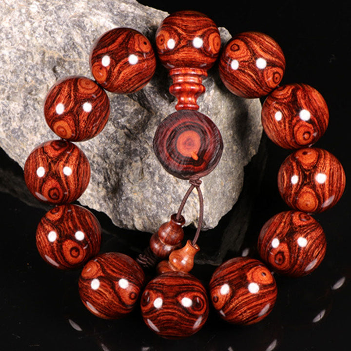 Armband Rosenholz mit weißen Punkten, Naturstein, Detailaufnahme auf Stein.