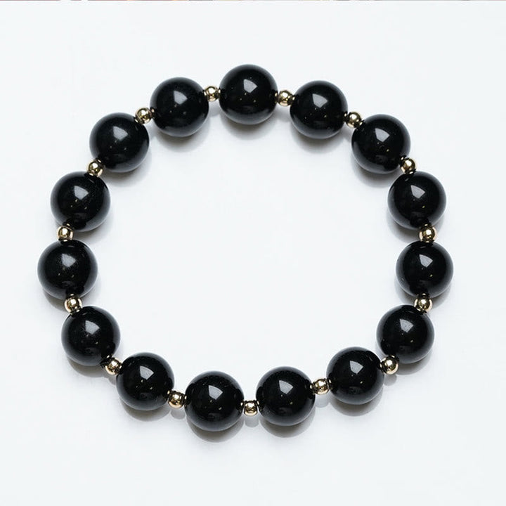 Armband Schwarzer Onyx – Schutz mit goldenen Perlen elegant gestaltet