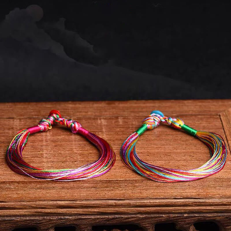 Zwei bunte Armbänder Fünffarben – Schutz Energie auf Holzoberfläche.