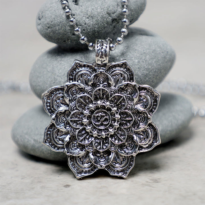 Kette Stein Lotus – Bild 5 – Silberne Lotus Kette mit Mandala Anhänger auf grauen Steinen