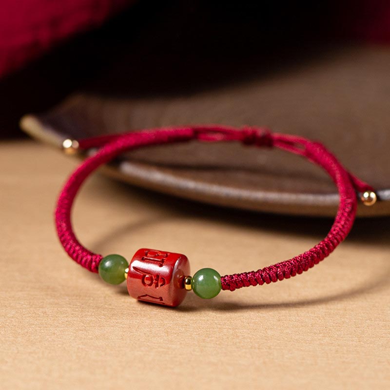 Rotes Armband mit grünen Jadekugeln und Om-Anhänger Zinnober Segen Balance.