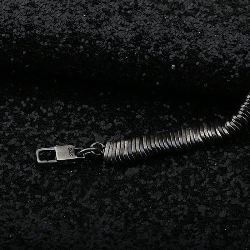 Silbernes Armband 925 mit Verschluss auf dunklem Untergrund liegend.