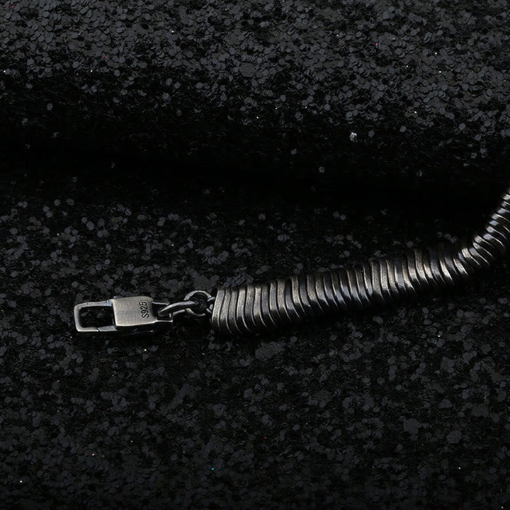 Silbernes Armband 925 mit Verschluss auf dunklem Untergrund liegend.