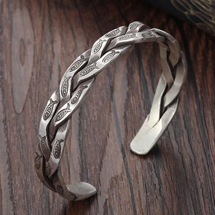 Silbernes Koi Fisch Armband mit Gravur auf Holzhintergrund elegant.