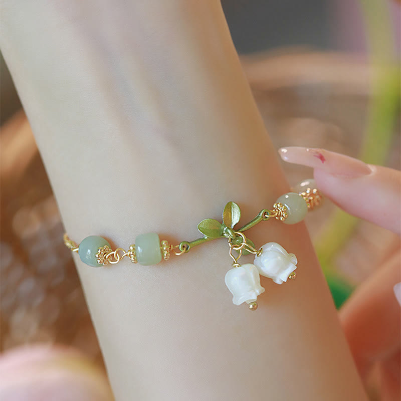 Armband Grüne Jade – Wohlstand mit weißen Blütenanhängern elegant getragen