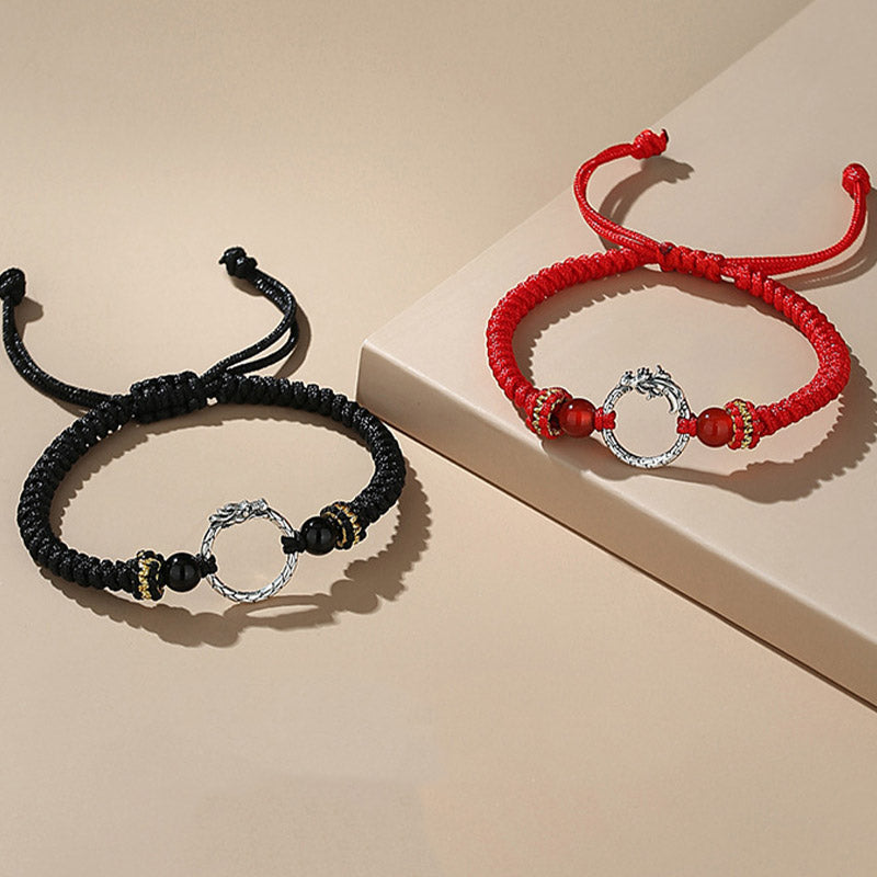 Zwei Armbänder mit Phönix-Anhänger, schwarz und rot, Silber-Details.