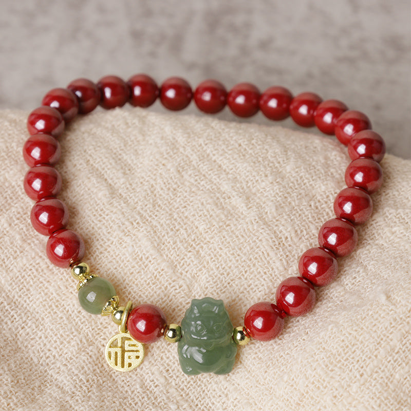 Rotes Armband mit Jade-Anhänger und goldenen Akzenten elegant präsentiert.