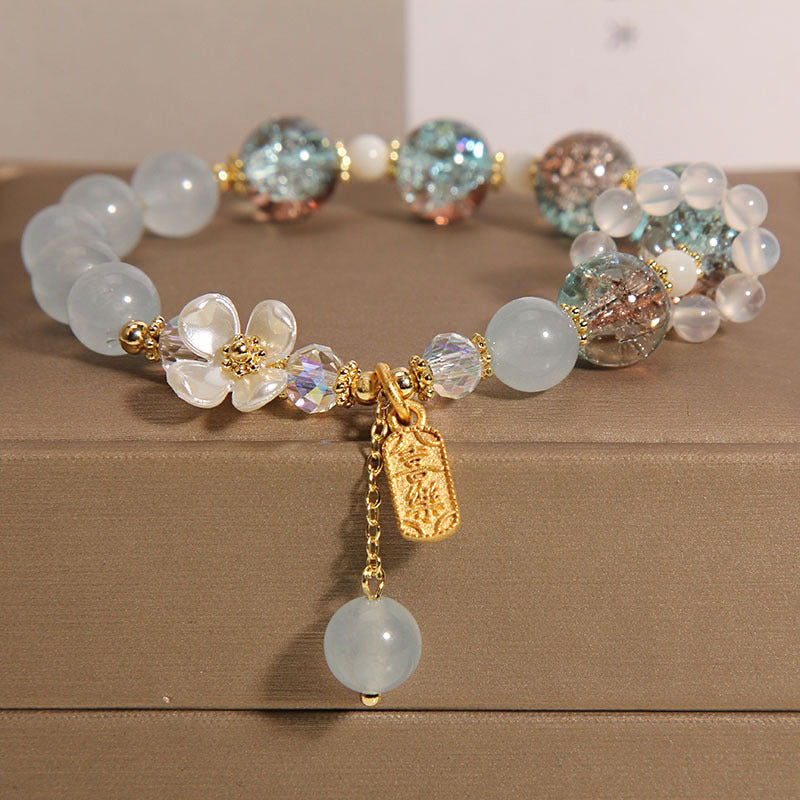 Elegantes Armband mit Mondstein und Kristallen, goldene Verzierungen, Charm-Anhänger.