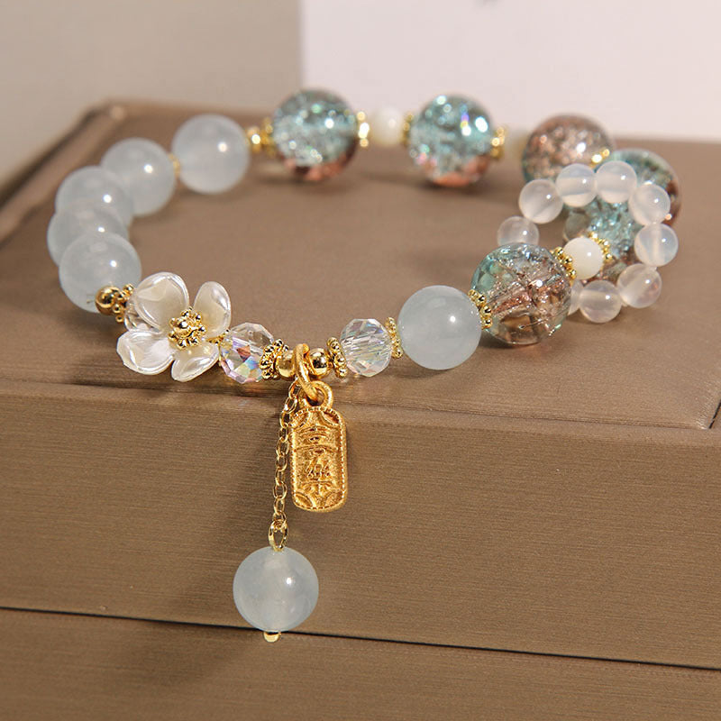 Elegantes Armband mit Mondstein und Kristallperlen, goldene Akzente, Anhänger.