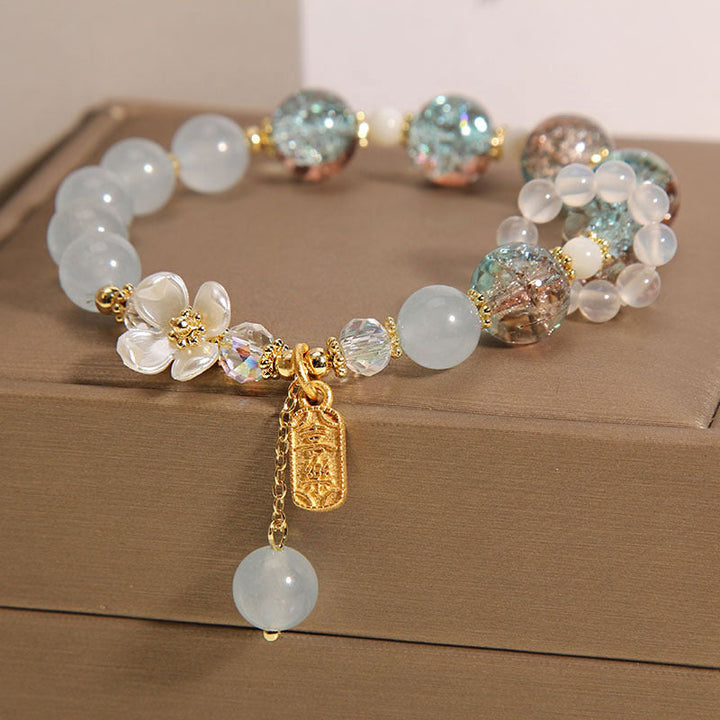 Elegantes Armband mit Mondstein und Kristallperlen, goldene Akzente, Anhänger.