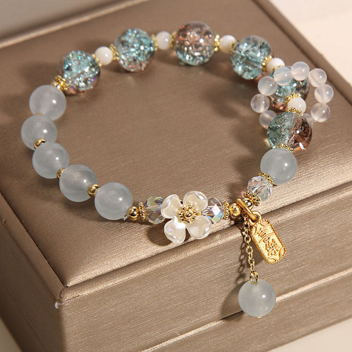 Elegantes Armband mit Mondstein und Kristallperlen auf Beige.