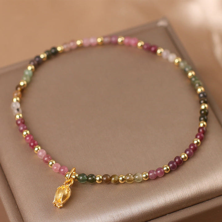 Buntes Turmalin Armband mit goldenen Perlen und Blumenanhänger elegant.