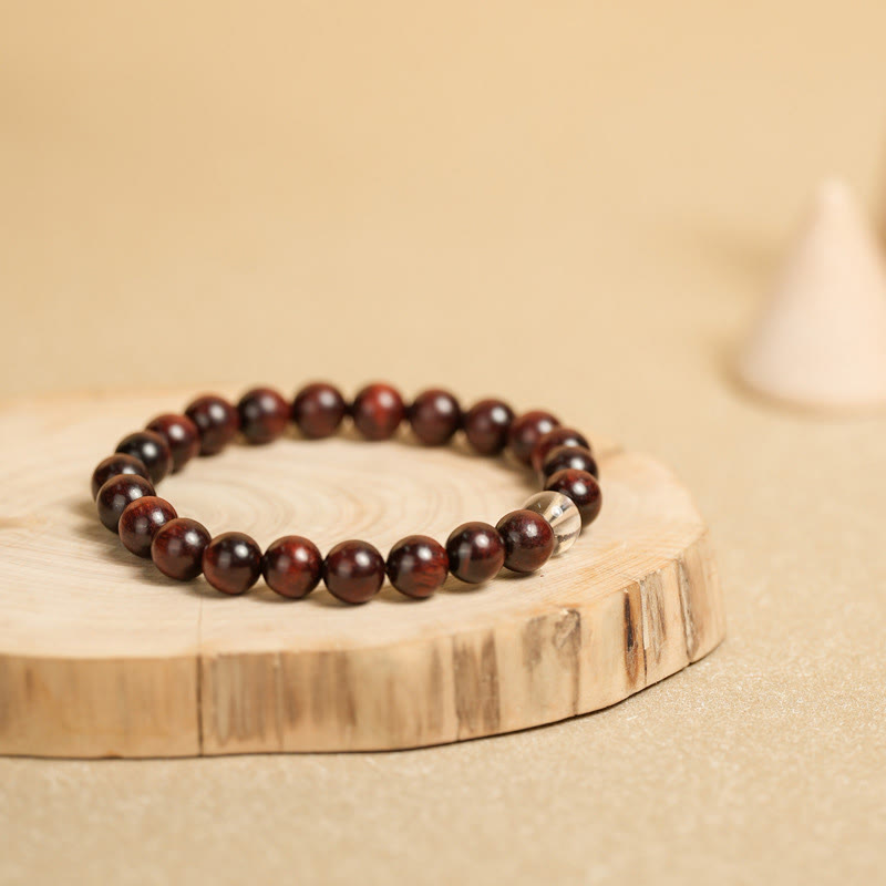 Dunkelrotes Sandelholz Armband mit silbernem Akzent elegant präsentiert.