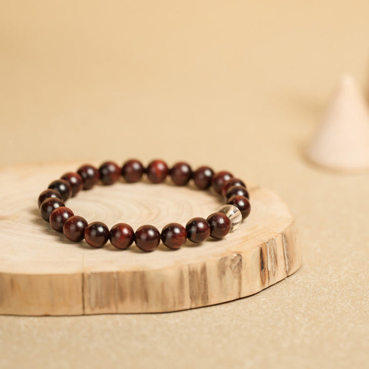 Dunkelrotes Sandelholz Armband mit silbernem Akzent elegant präsentiert.