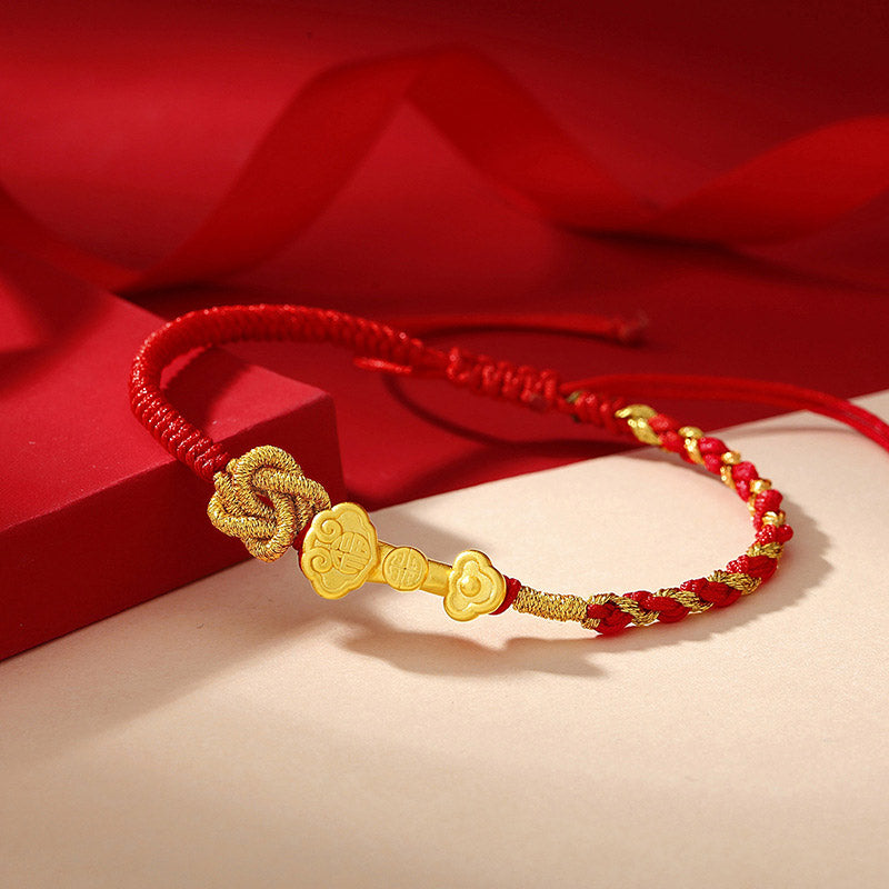 Rotes Armband mit goldenem Fu-Zeichen Charm elegant am Handgelenk getragen