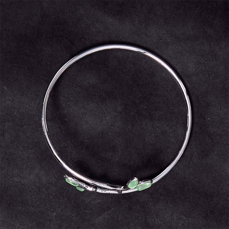 Silbernes Armband mit grünen Blatt-Katzenauge-Steinen elegant präsentiert