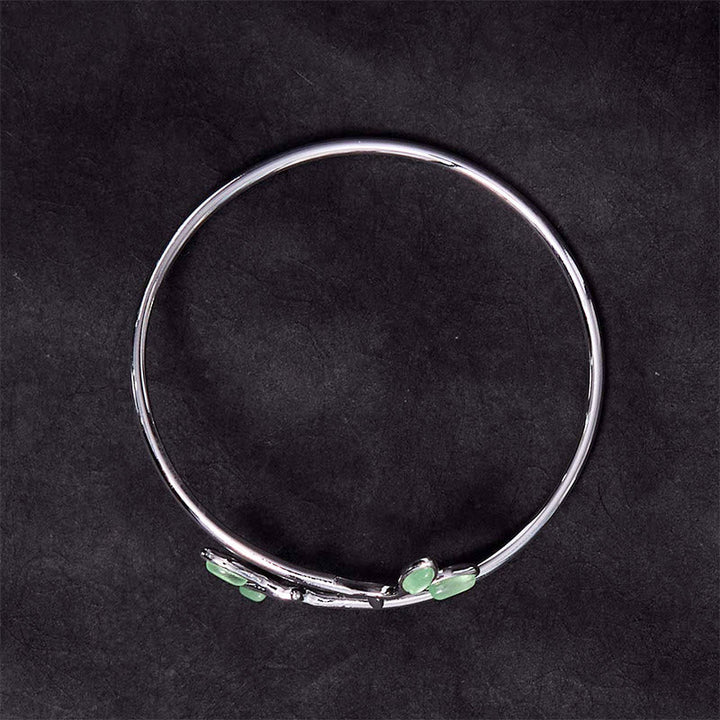 Silbernes Armband mit grünen Blatt-Katzenauge-Steinen elegant präsentiert