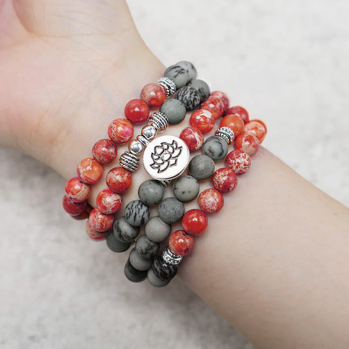 Armband Lotus – Schutz mit roten und grauen Perlen am Handgelenk getragen