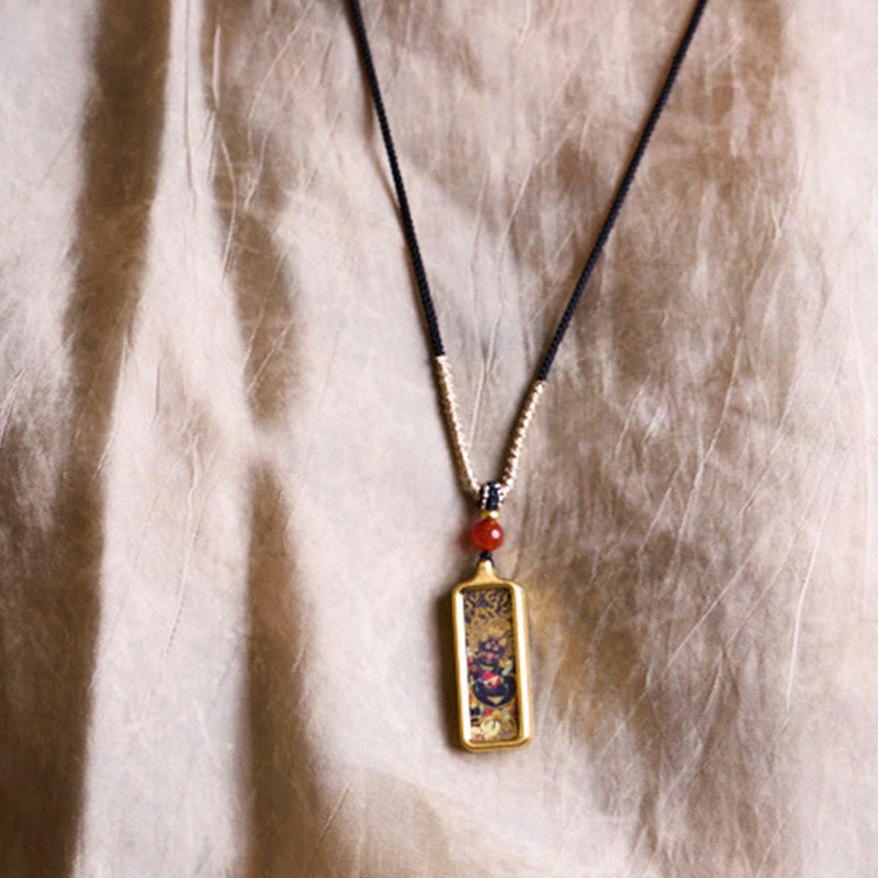 Schmuck Kette mit goldenem Anhänger rote Perle am Hals