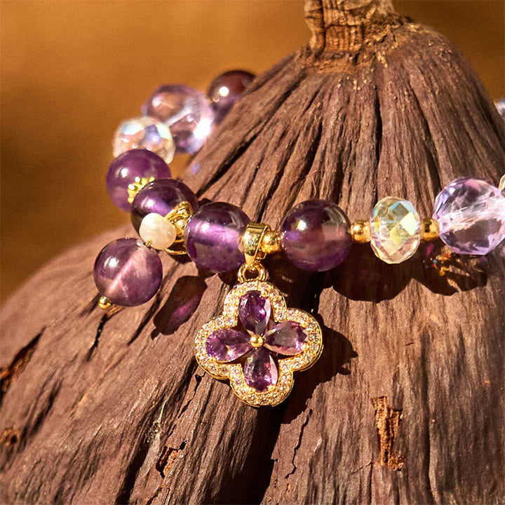 Amethyst Kristall Kleeblatt Armband mit lila Perlen auf Holz.