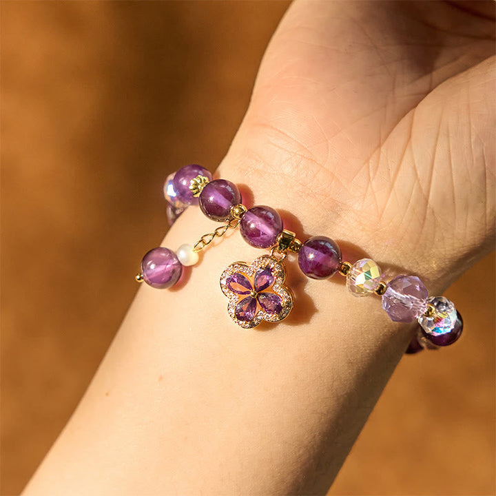 Amethyst Kristall Kleeblatt Armband am Handgelenk mit lila Steinen.