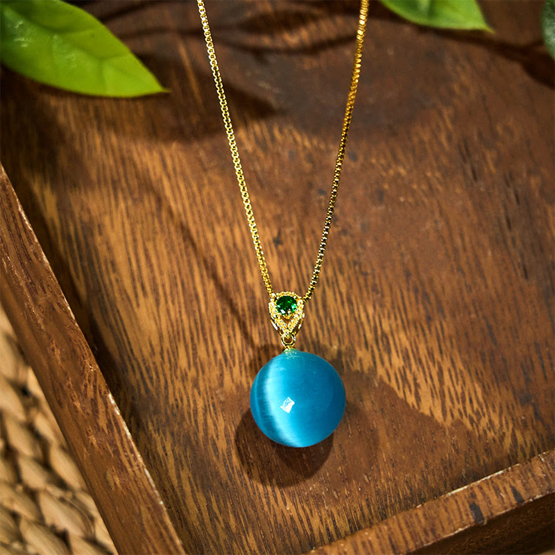 Blaue Katzenauge Kette mit Buddha-Kugel Anhänger auf Holz