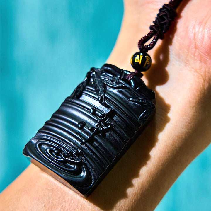 Obsidian Anhänger Kette am Handgelenk getragen schwarzer Naturstein Bambus