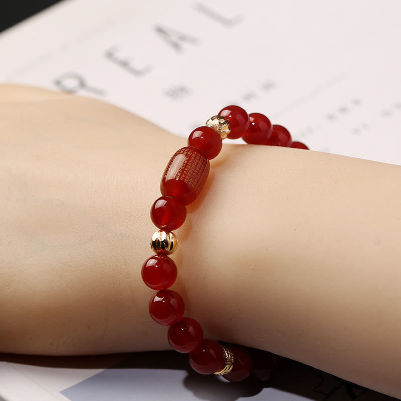 Armband Roter Achat am Handgelenk mit goldenen Perlenakzenten getragen