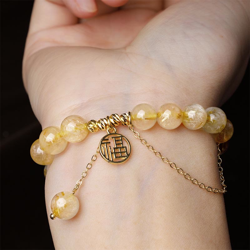 Armband Citrin Fu-Zeichen – Glück am Handgelenk mit goldenem Charm getragen