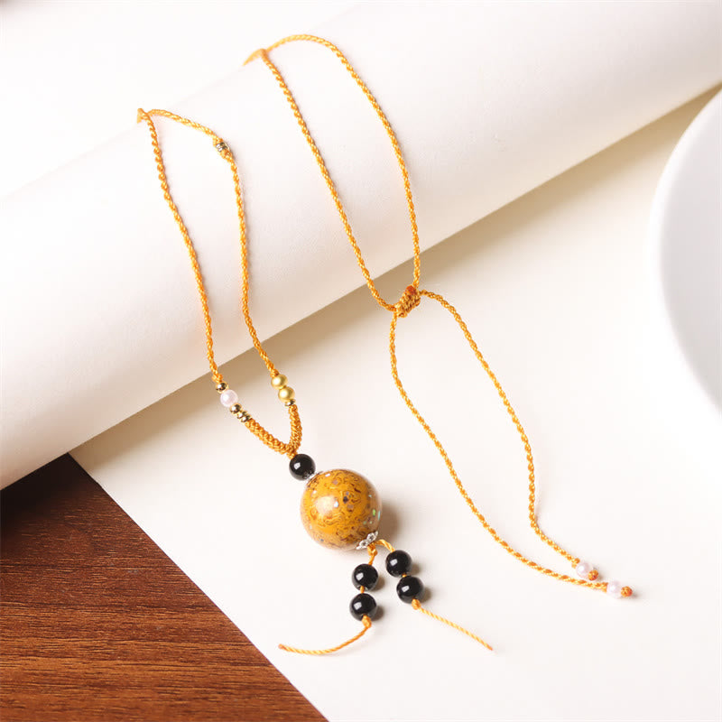 Goldfarbene Kette mit Ebenholz Perlmutt Buddha Anhänger Naturstein Balance
