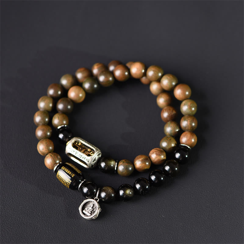 Armband Sandelholz Obsidian mit Metallverzierungen auf grauem Hintergrund
