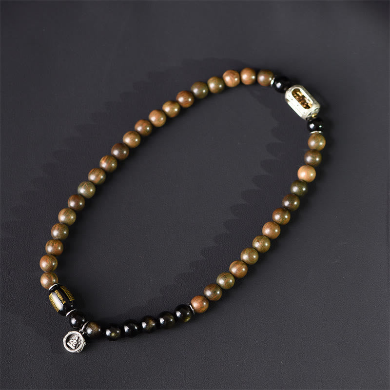 Armband Sandelholz Obsidian mit silbernen Verschlüssen auf grauem Hintergrund.